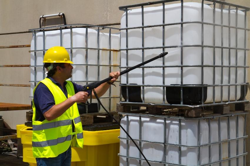 Mann reinigt IBC Container