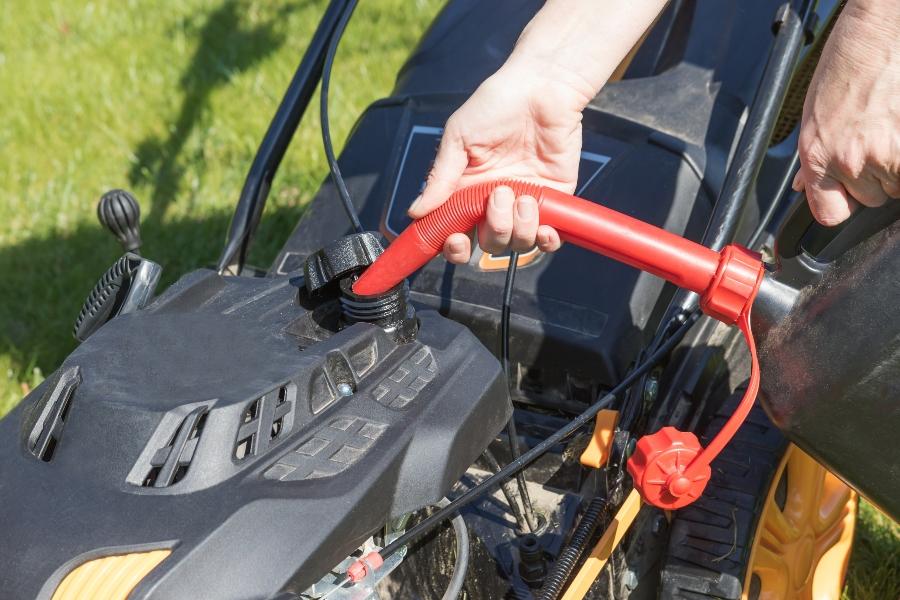 Benzin in den Tank des Diesel-Rasenmaehers giessen