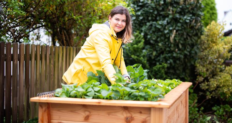 Frau arbeitet an Hochbeet