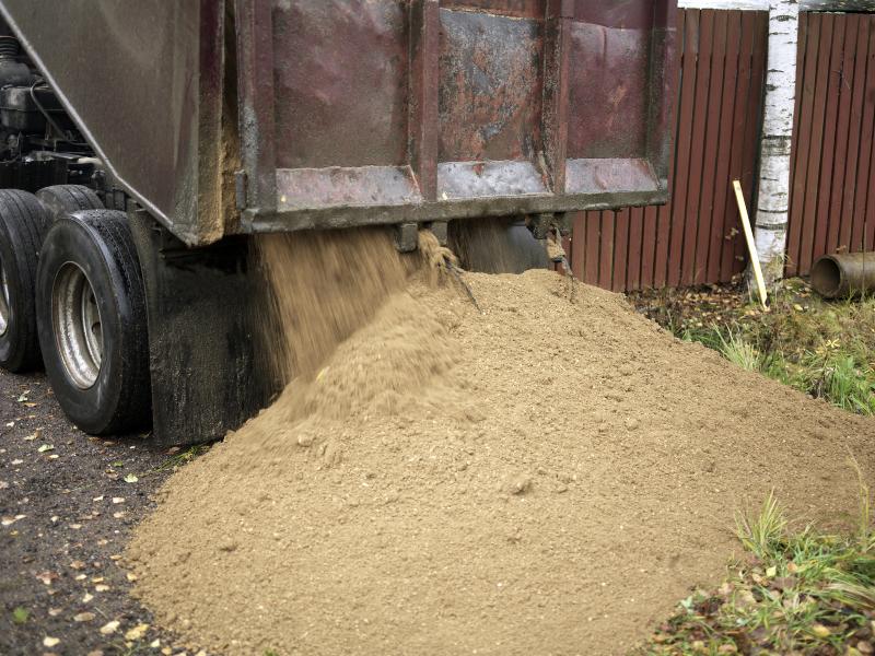 Sand wird von einem LKW abgeladen