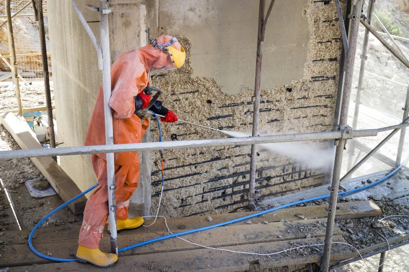 Mann benutzt Wasserstrahler auf Baustelle