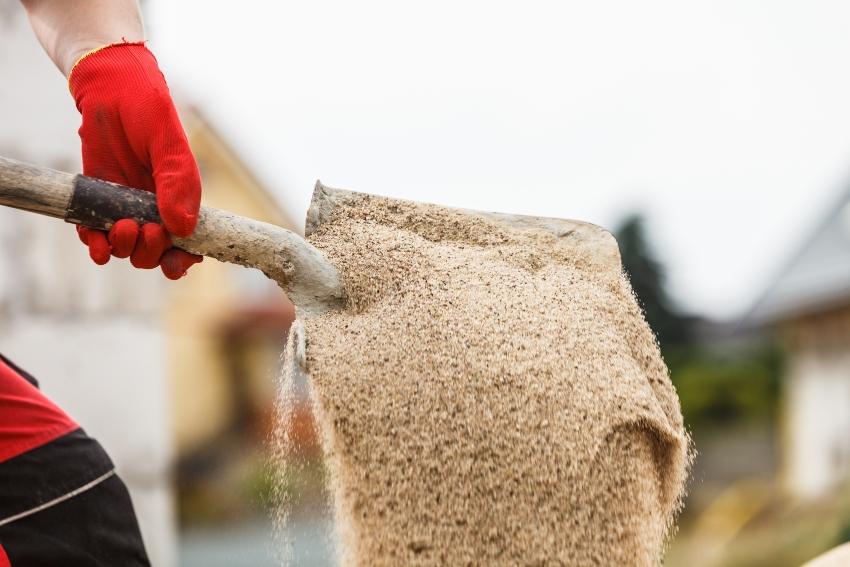 Schaufel mit Sand - beim Teich anlegen kann mithilfe von Sand ein Filter gebaut werden