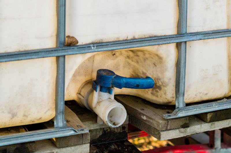 Ein etwas schmutziger Ablaufhahn an der Vorderseite eines IBC-Containers 