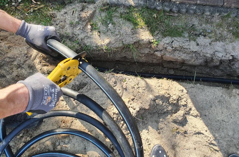 Jemand schneide Schläuche für ein Pipeline-System 