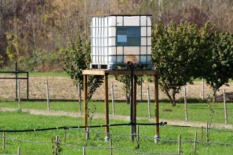 Ein IBC-Container ist auf einem hohen Podest platziert und wird als Hochtank genutzt