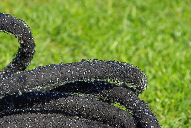 Ein Perlschlauch, aus dessen Poren Wassertropfen austreten