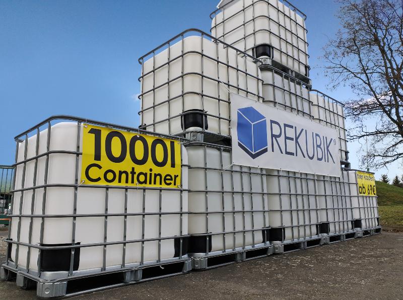 Einige 1000-Liter-Container sind aufeinander gestapelt, an ihnen ist ein Transparent mit der Aufschrit "1000l Container" befestigt Wasserspeicher