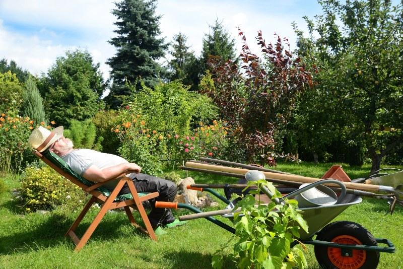 Ein Gärtner liegt im Gartenstuhl, hält ein Nickerchen und genießt die Sonne Bodenfeuchtigkeitssensoren