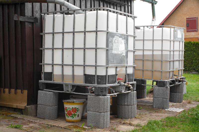 Zwei IBC-Container werden als Regenauffangbehälter im Garten genutzt