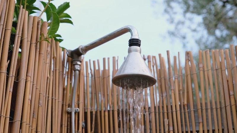 Eine Gartendusche, die mit einem Sichtschutz aus Bubus umgeben ist