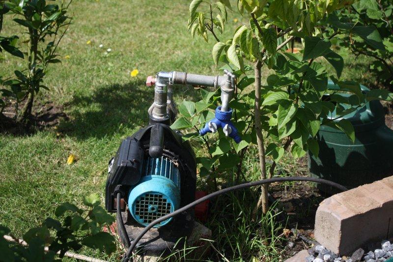 Eine Gartenpumpe ist an eine Verlegte PE-Leitung angeschlossen und sorgt für den erforderlichen Druck