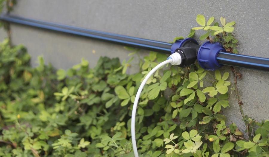 Wassersteckdose mit Leitung an Hauswand