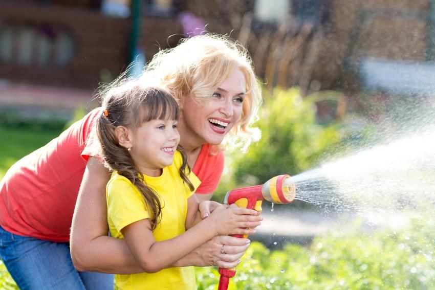 Mutter und Tochter bei der Gartenbewässerung