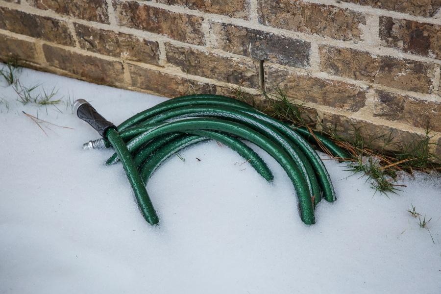 Gartenschlauch liegt im Schnee