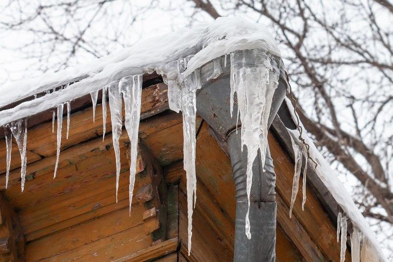 Ein vereistes Fallrohr an dem sich lange Eiszapfen gebildet haben