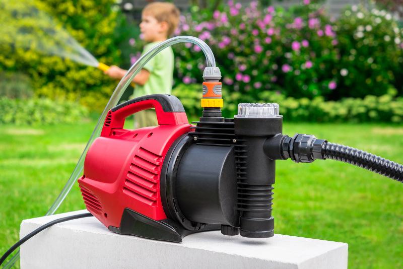 Eine Pumpe für die Gartenbewässerung versorgt einen Gartenschlauch mit Wasser