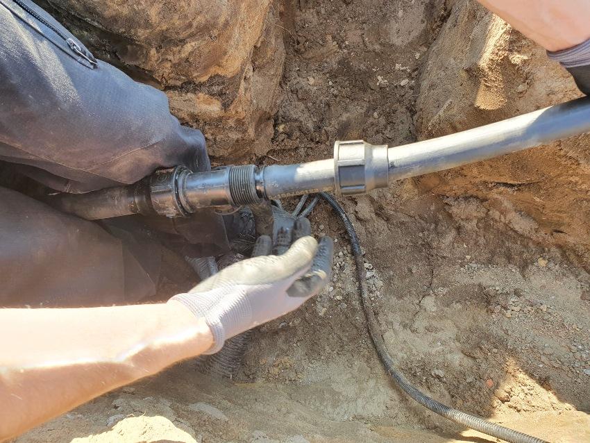 Jemand verlegt Rohre für die Gartenbewässerung