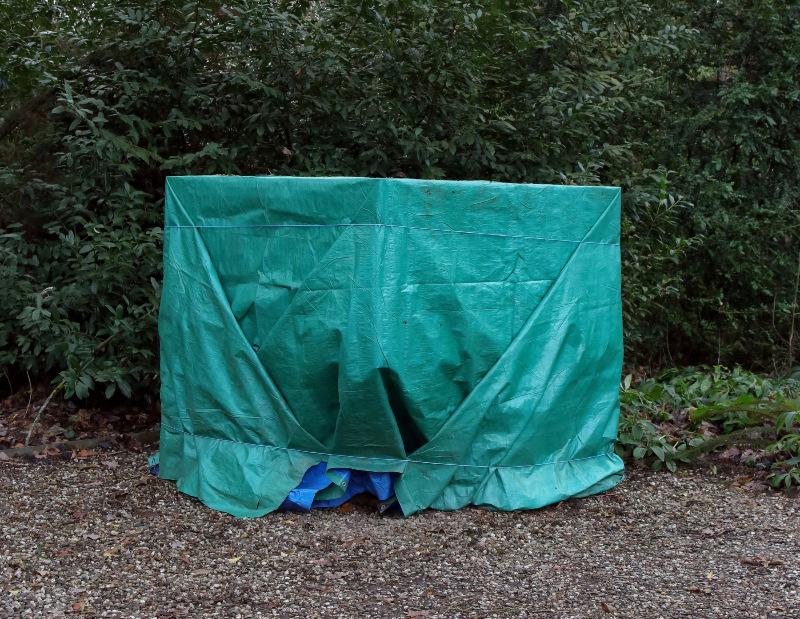 Im Garten steht ein IBC, der mit einer Hülle notdürftig verkleidet ist