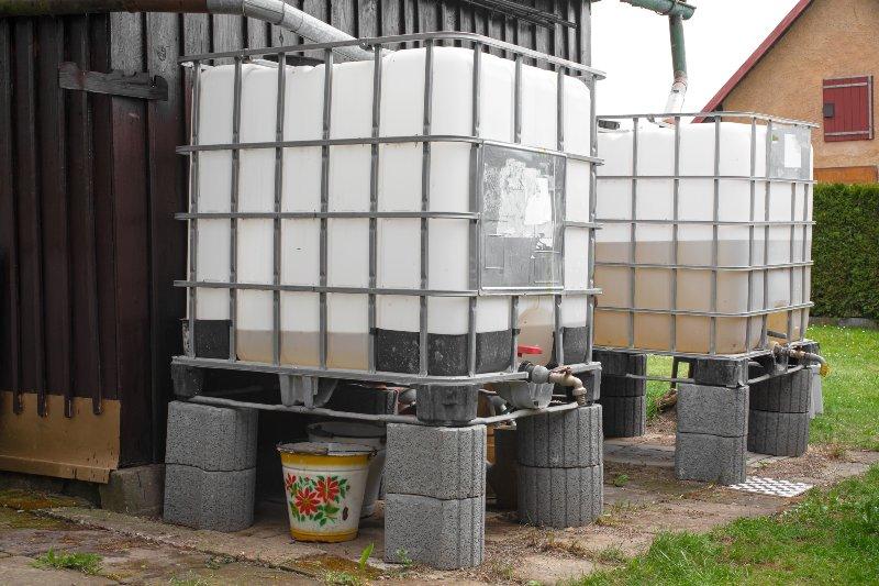 Zwei IBC-Container sind auf einem selbstgebauten Untergestell im Garten platziert
