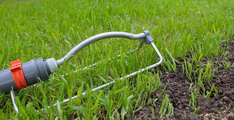 Ein Flächenregner steht auf einer frisch ausgesäten Rasenfläche Rasensaat wässern Rasensaat wässern