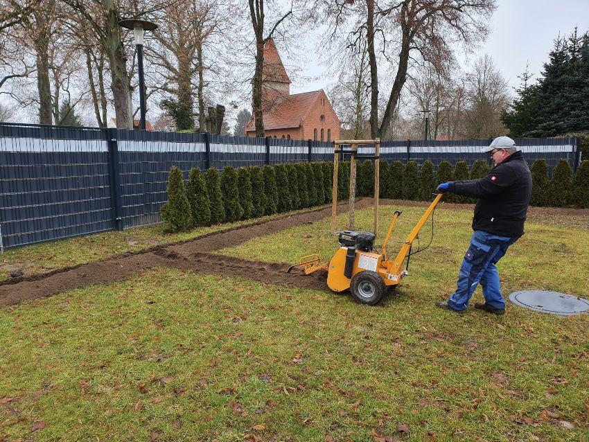 Handwerker nutzt Grabenfraese fuer spaetere Wasserleitungen