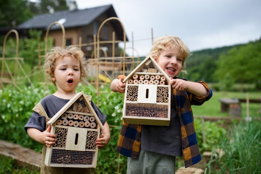 2 Kinder jeweils mit einem Insektenhotel - Garten ökologisch gestalten