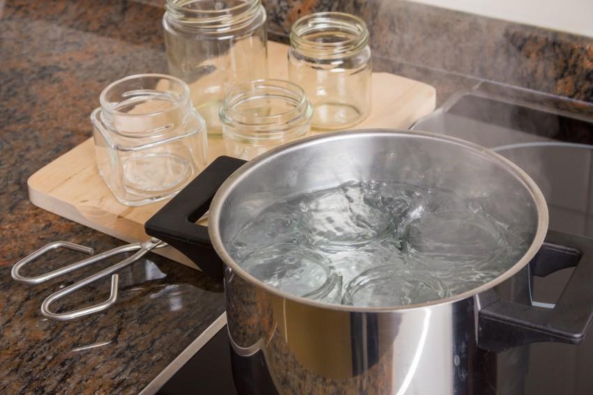 Wasser kocht im Topf, Weckgläser im Hintergrund