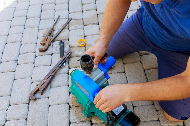 Ein Mann repariert eine Gartenpumpe