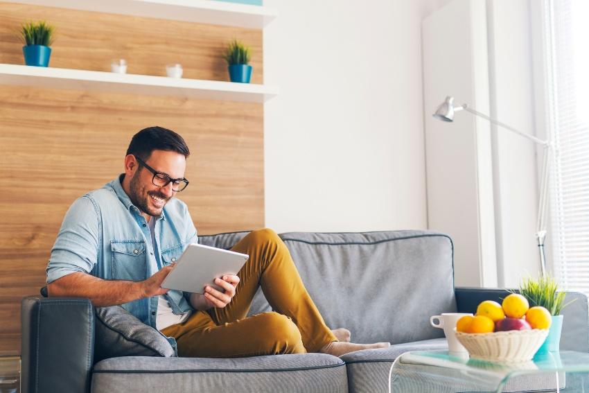 Mann-sitzt-auf-Couch-mit-Tablet-Computer