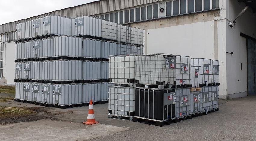 Viele IBCs, gestapelt vor Gebaeude - IBC Container Haltbarkeit – Wie lange ist der Tank nutzbar?