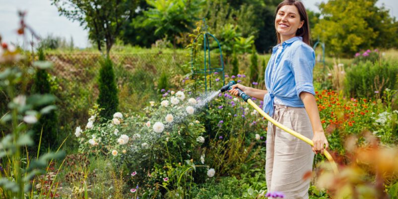 Frau-giesst-Blumen-im-Grten-Welche-Pflanzen-brauchen besonders viel Wasser